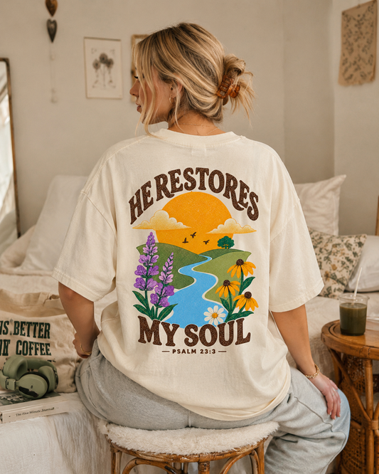 Ivory Comfort Colors t-shirt with He Restores My Soul Psalm 23:3 coastal sunrise landscape back design